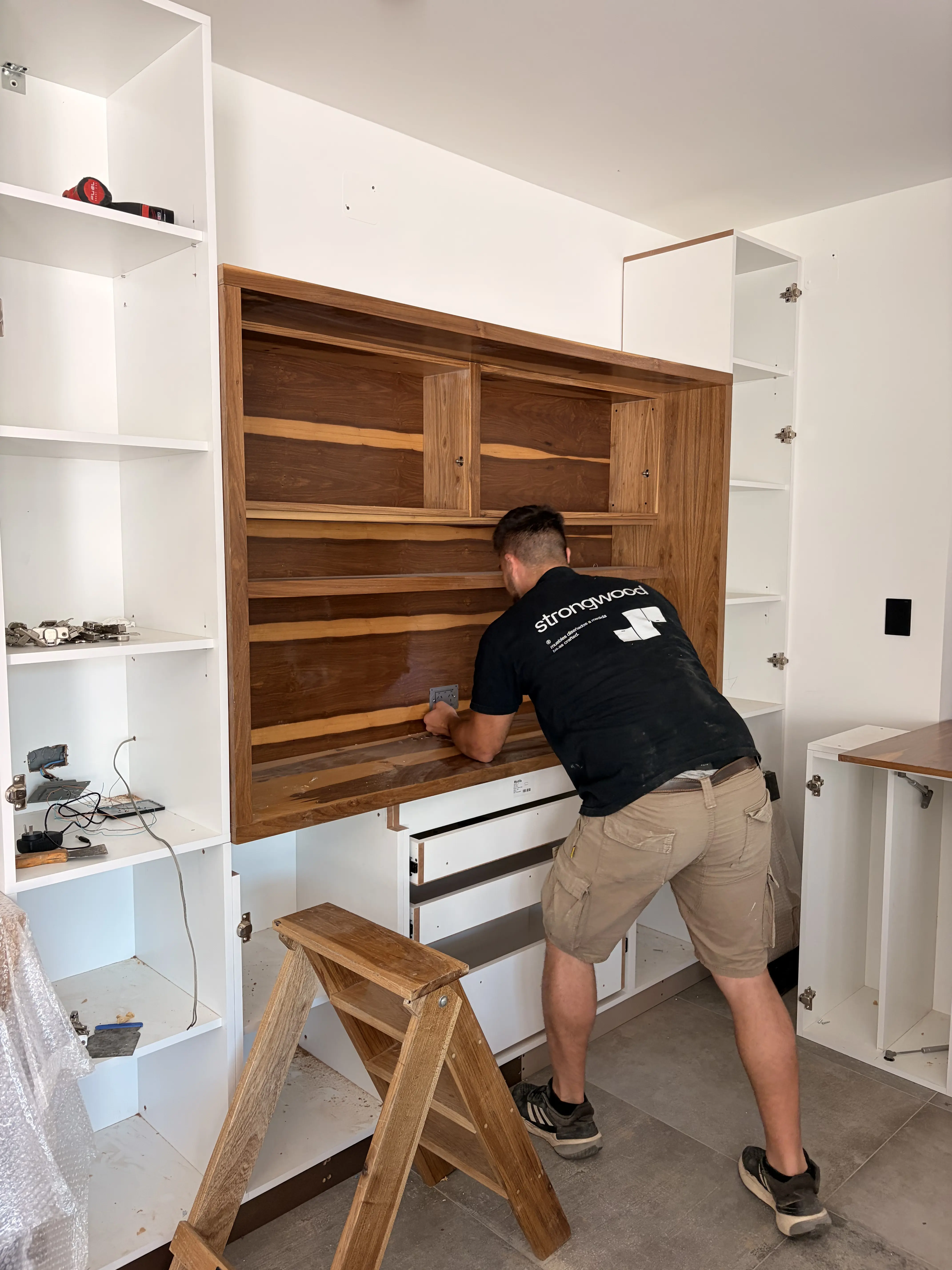Integración de estantería de madera clara con muebles de cocina laqueados