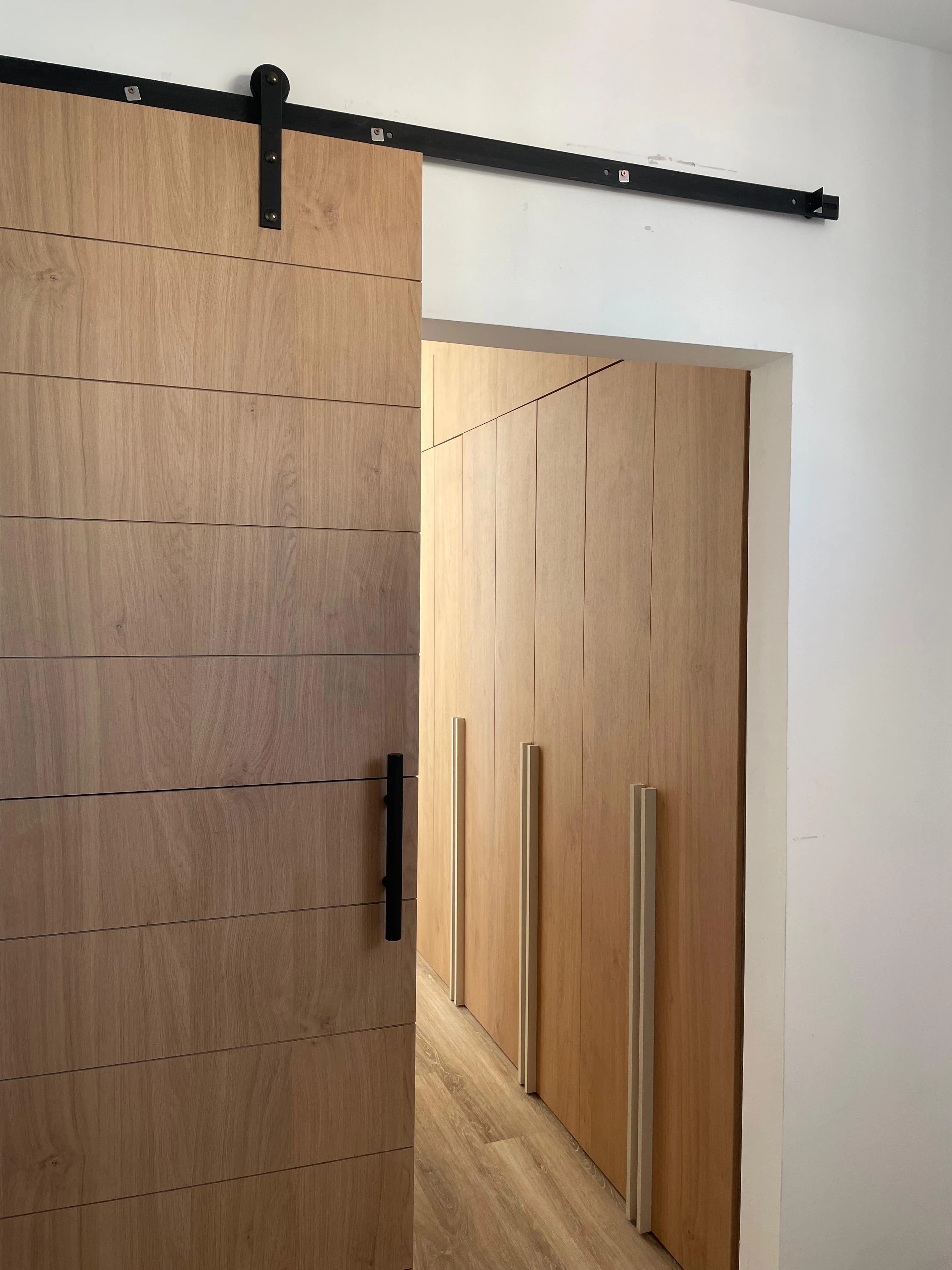 Puerta corrediza de madera con herrajes ocultos