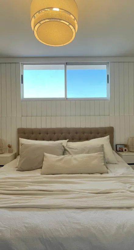 Dormitorio con paredes revestidas en láminas de madera
