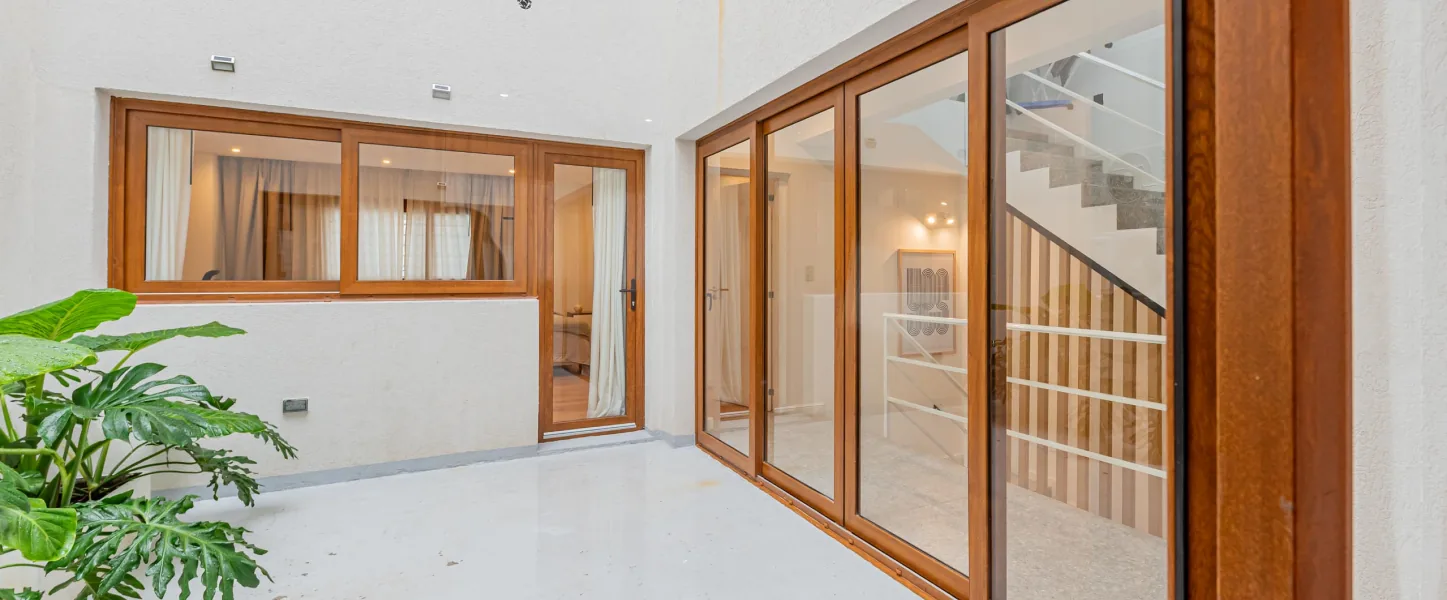 Patio con puertas y ventanas de madera y ventanal