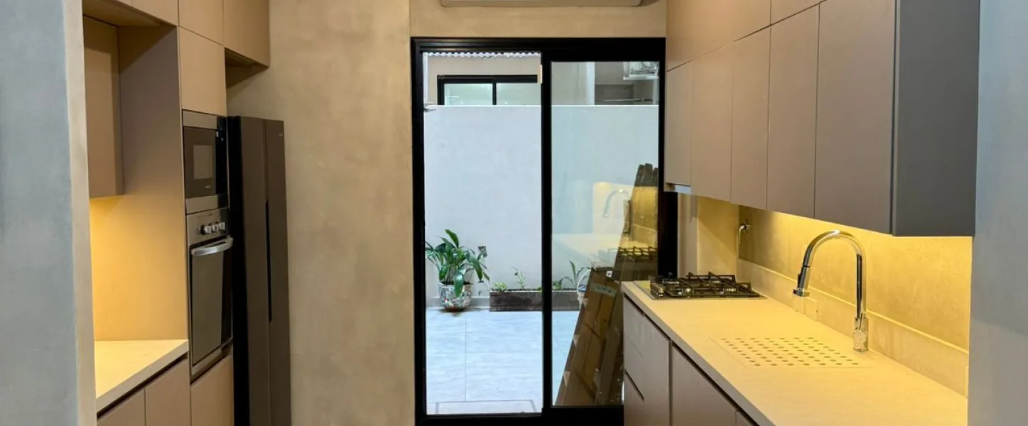 Cocina con iluminación cálida y muebles de melamina