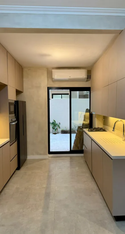 Cocina con iluminación cálida y muebles de melamina