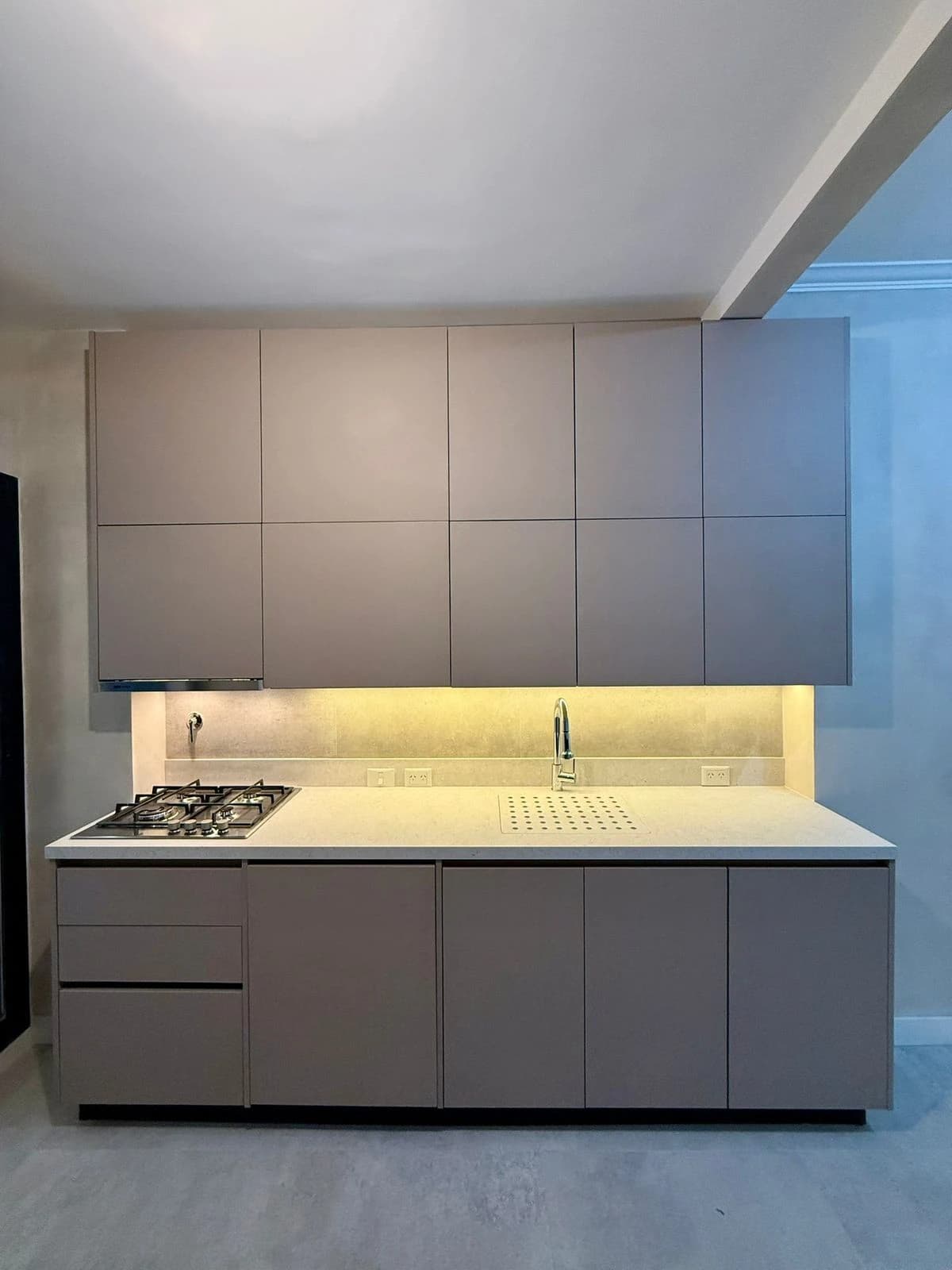 Cocina con muebles gris minimalista y mesada clara