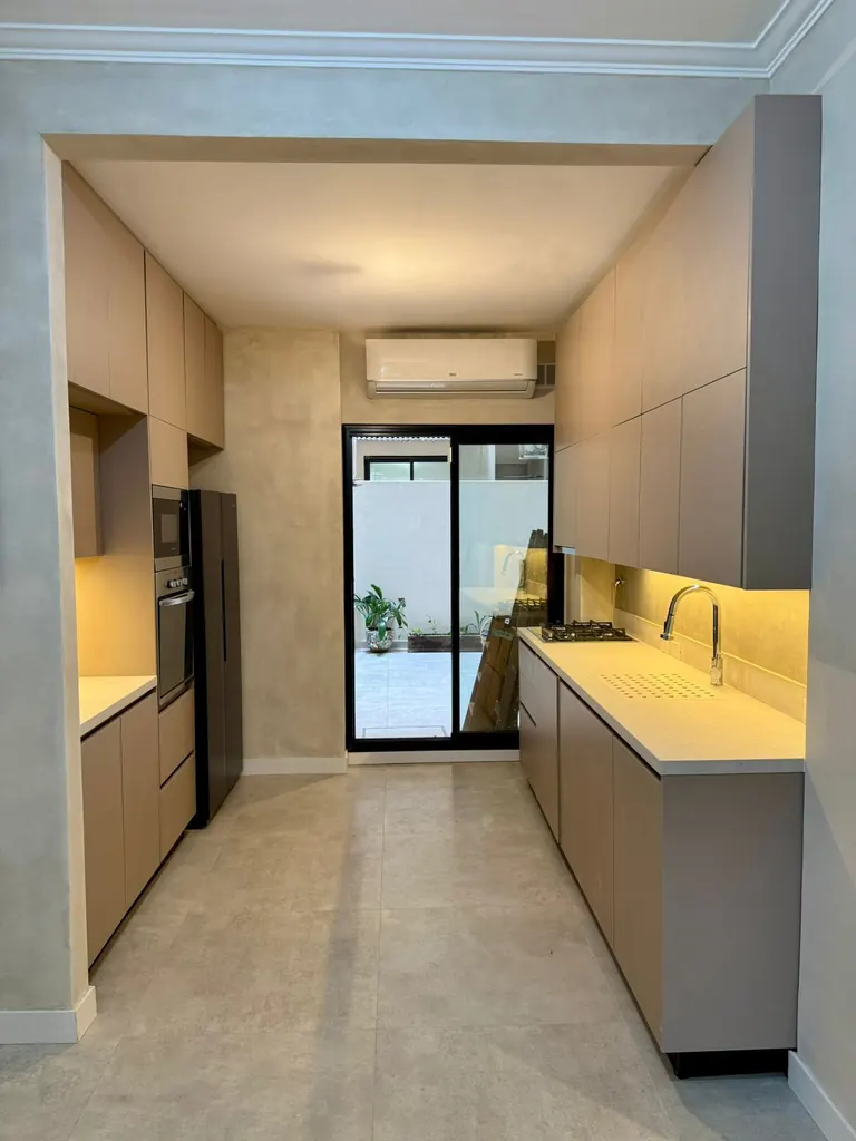 Cocina con iluminación cálida y muebles de melamina
