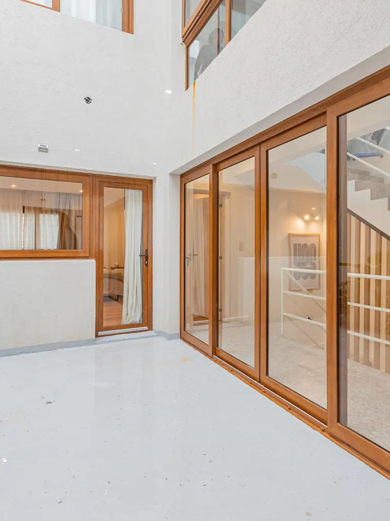 Patio con puertas y ventanas de madera y ventanal